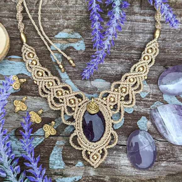 Handcrafted macramé necklace with an Amethyst gemstone centerpiece and brass details, perfect as a gift from a small business for hippie, and wellbeing-focused clients.