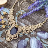 Handcrafted macramé necklace with an Amethyst gemstone centerpiece and brass details, perfect as a gift from a small business for hippie, and wellbeing-focused clients.