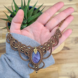 Handcrafted macramé necklace with an amethyst gemstone centerpiece and brass details, perfect as a gift from a small business for hippie, spiritual, and wellbeing-focused clients.