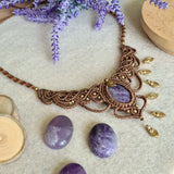 Handcrafted macramé necklace with an amethyst gemstone centerpiece and brass details, perfect as a gift from a small business for hippie, spiritual, and wellbeing-focused clients.