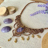 Handcrafted macramé necklace with an amethyst gemstone centerpiece and brass details, perfect as a gift from a small business for hippie, spiritual, and wellbeing-focused clients.