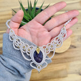 Handcrafted macramé necklace with an amethyst gemstone centerpiece and brass details, perfect as a gift from a small business for hippie, spiritual, and wellbeing-focused clients.