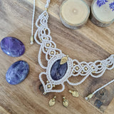 Handcrafted macramé necklace with an amethyst gemstone centerpiece and brass details, perfect as a gift from a small business for hippie, spiritual, and wellbeing-focused clients.