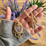 Handcrafted macramé pendant with a Rosa Quartz gemstone centerpiece and brass details, perfect as a gift from a small business for hippie, and wellbeing-focused clients.