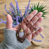 Handcrafted macramé pendant with a Rosa Quartz gemstone centerpiece and brass details, perfect as a gift from a small business for hippie, and wellbeing-focused clients.