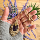 Handcrafted macramé pendant with an Amethyst gemstone centerpiece and brass details, perfect as a gift from a small business for hippie, and wellbeing-focused clients.