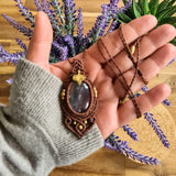 Handcrafted macramé pendant with an Amethyst gemstone centerpiece and brass details, perfect as a gift from a small business for hippie, and wellbeing-focused clients.