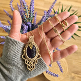 Handcrafted macramé pendant with an Amethyst gemstone centerpiece and brass details, perfect as a gift from a small business for hippie, and wellbeing-focused clients.