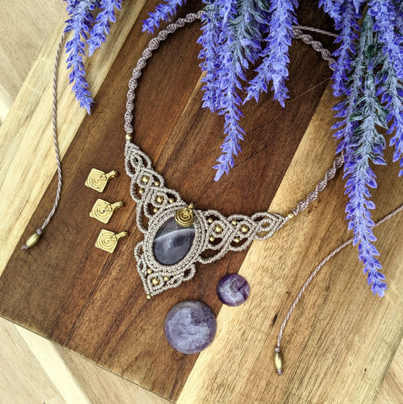 Handcrafted macramé necklace with an Amethyst gemstone centerpiece and brass details, perfect as a gift from a small business for hippie, spiritual, and wellbeing-focused clients.