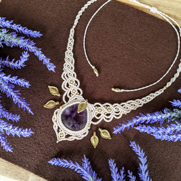 Handcrafted macramé necklace with an Amethyst gemstone centerpiece and brass details, perfect as a gift from a small business for hippie, spiritual, and wellbeing-focused clients.