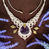 Handcrafted macramé necklace with an Amethyst gemstone centerpiece and brass details, perfect as a gift from a small business for hippie, spiritual, and wellbeing-focused clients.