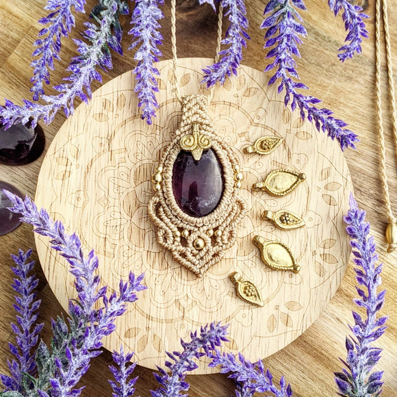 Handcrafted macramé pendant with an Amethyst gemstone centerpiece and brass details, perfect as a gift from a small business for hippie, and wellbeing-focused clients.