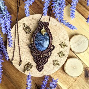 Handcrafted macramé pendant with a Sodalite gemstone centerpiece and brass details, perfect as a gift from a small business for hippie, and wellbeing-focused clients.