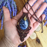 Handcrafted macramé pendant with a Sodalite gemstone centerpiece and brass details, perfect as a gift from a small business for hippie, and wellbeing-focused clients.