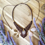 Handcrafted macramé necklace with a Rosa Quartz gemstone centerpiece and brass details, perfect as a gift from a small business for hippie, and wellbeing-focused clients.