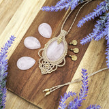 Handcrafted macramé pendant with a Rosa Quartz gemstone centerpiece and brass details, perfect as a gift from a small business for hippie, and wellbeing-focused clients.