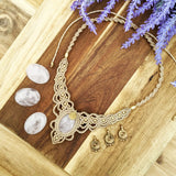 Handcrafted macramé necklace with a Rosa Quartz gemstone centerpiece and brass details, perfect as a gift from a small business for hippie, and wellbeing-focused clients.