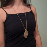 Handcrafted macramé pendant with a Rosa Quartz gemstone centerpiece and brass details, perfect as a gift from a small business for hippie, and wellbeing-focused clients.