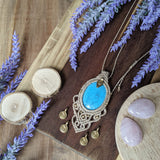 Handcrafted macramé pendant with a Dyed Magnesite gemstone centerpiece and brass details, perfect as a gift from a small business for hippie, and wellbeing-focused clients.