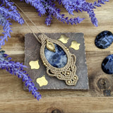 Handcrafted macramé pendant with a Sodalite gemstone centerpiece and brass details, perfect as a gift from a small business for hippie, and wellbeing-focused clients.